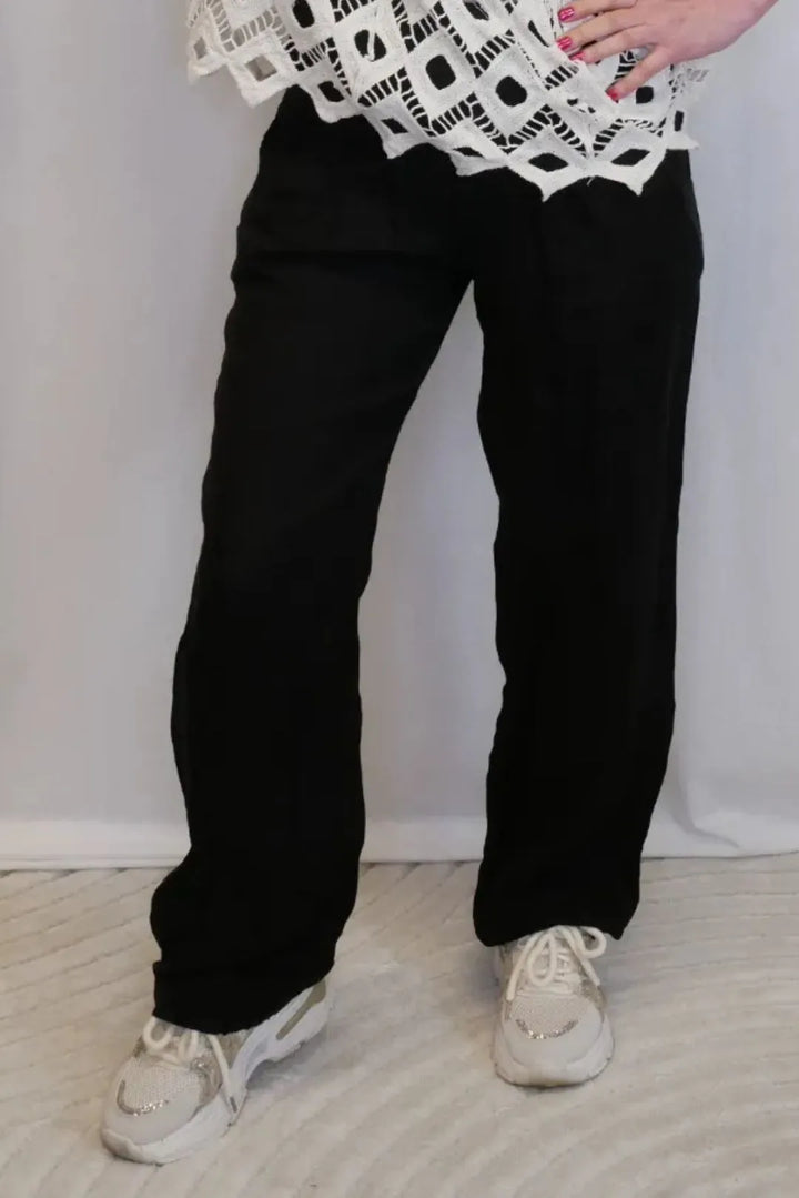 Leveälahkeiset pellavahousut resorilla