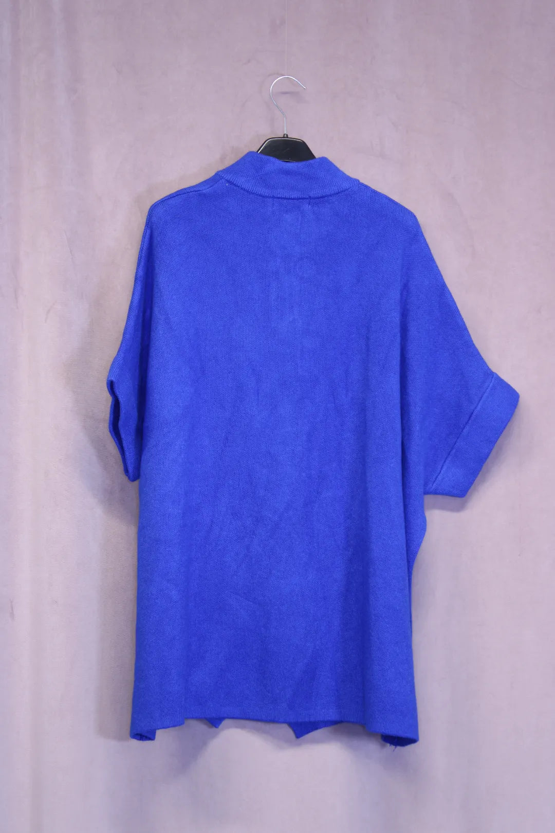 Lyhythihainen neule Anu, kaunis sininen neuletakki taustalta, jossa lyhyet hihat ja kaulus.